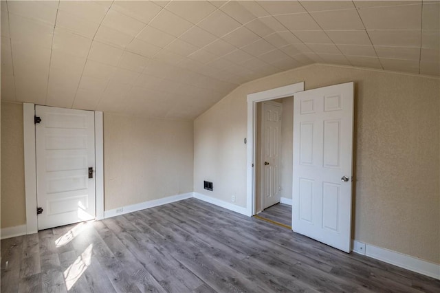 additional living space featuring vaulted ceiling, baseboards, and wood finished floors