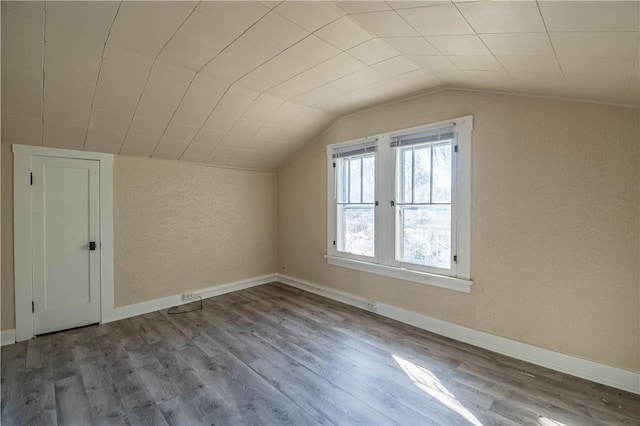 bonus room featuring vaulted ceiling, wood finished floors, and baseboards