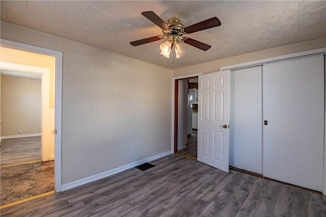 unfurnished bedroom with a ceiling fan, wood finished floors, baseboards, and a closet