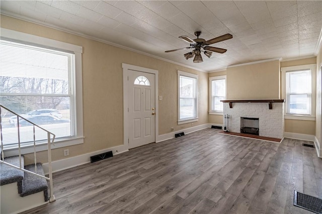 unfurnished living room with a healthy amount of sunlight, wood finished floors, a ceiling fan, and ornamental molding