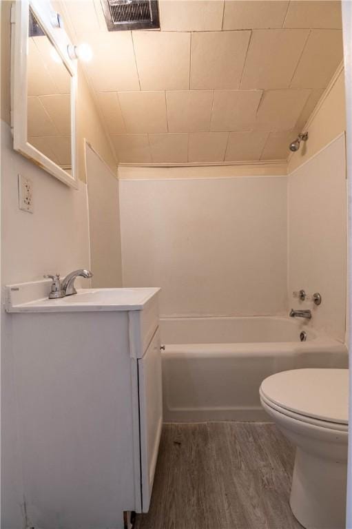 bathroom with visible vents, toilet,  shower combination, and wood finished floors