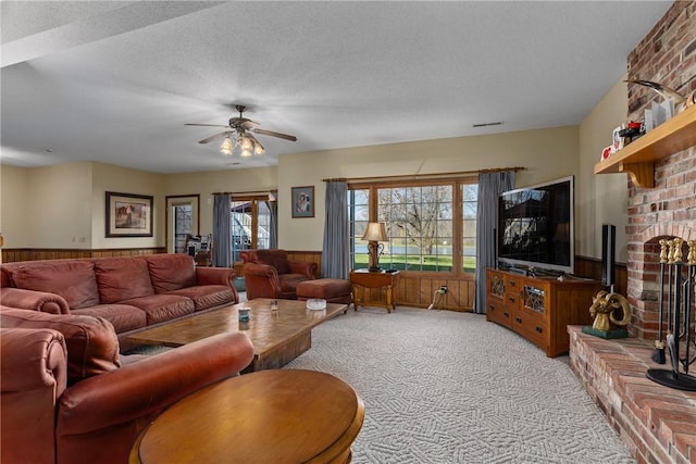 11284 E Lincolnshire Ln, Effingham, IL 62401 - carpeted living room with wainscoting, a fireplace, a ceiling fan, a textured ceiling, and wood walls