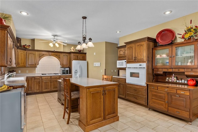 11284 E Lincolnshire Ln, Effingham, IL 62401 - kitchen with white appliances, a sink, light tile patterned flooring, a ceiling fan, and brown cabinetry