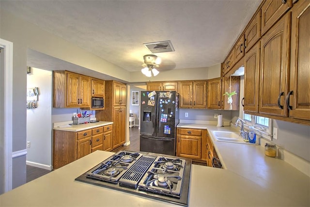8070 Cerro Gordo Blacktop, Oakley, IL 62501 - kitchen with visible vents, black fridge with ice dispenser, light countertops, and stovetop with downdraft
