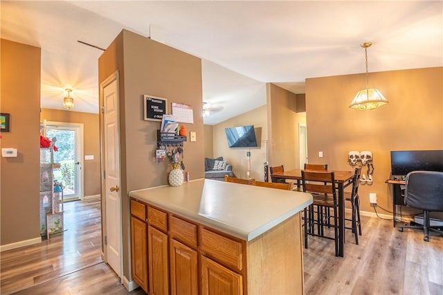 130 S Illinois St, Warrensburg, IL 62573 - kitchen featuring open floor plan, light wood-type flooring, decorative light fixtures, light countertops, and vaulted ceiling