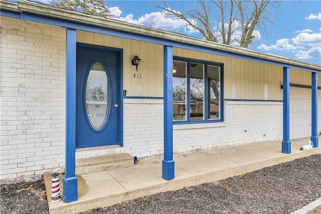 doorway to property featuring brick siding