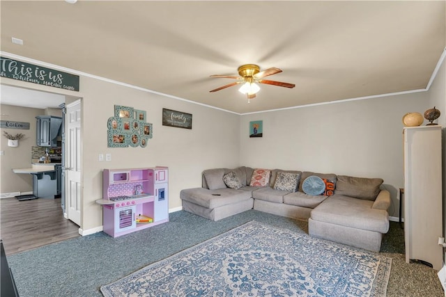 living area with ceiling fan, baseboards, and crown molding