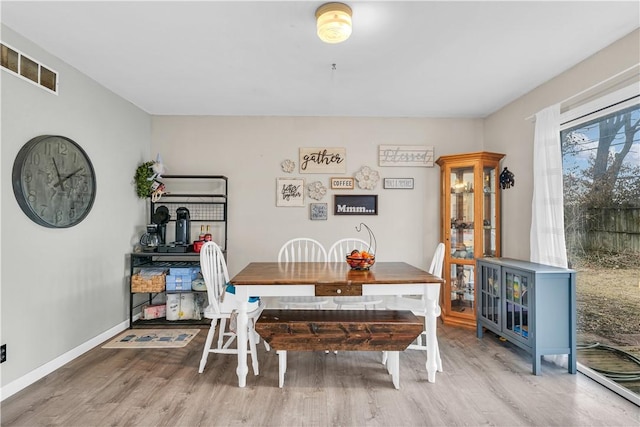 dining space with visible vents, baseboards, and wood finished floors