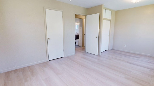 unfurnished bedroom with baseboards and light wood-type flooring