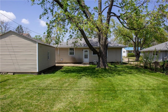 back of property featuring a yard and fence