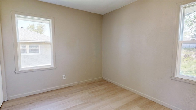 spare room featuring baseboards and light wood-style flooring
