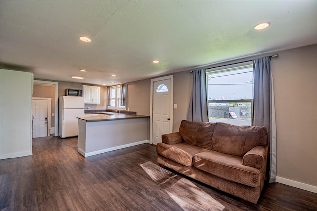 living area featuring recessed lighting, dark wood finished floors, and baseboards