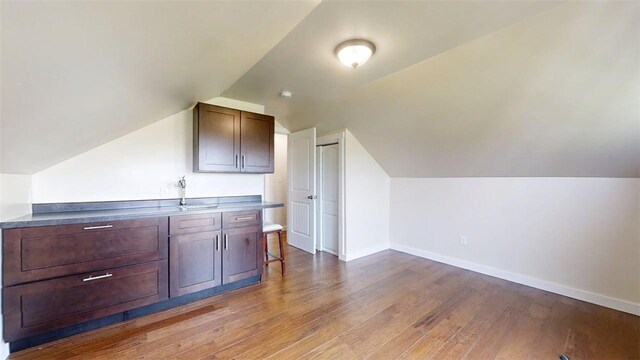 67 Shores, Sullivan, IL 61951 - additional living space with wood finished floors, vaulted ceiling, baseboards, and a sink