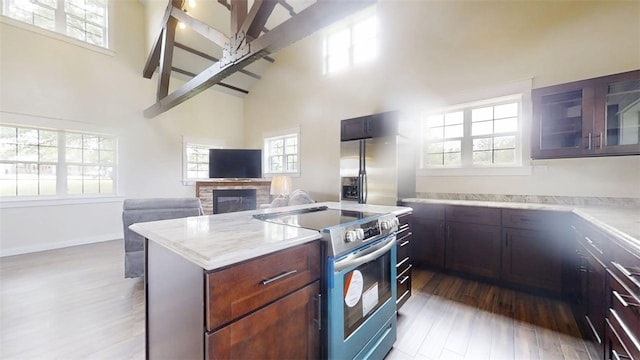 67 Shores, Sullivan, IL 61951 - kitchen featuring appliances with stainless steel finishes, high vaulted ceiling, wood finished floors, a kitchen island, and a fireplace
