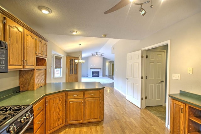 8898 Country Side Dr, Dalton City, IL 61925 - kitchen with vaulted ceiling, a peninsula, brown cabinets, ceiling fan, and light wood-type flooring