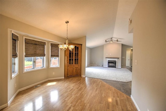 8898 Country Side Dr, Dalton City, IL 61925 - unfurnished living room with a chandelier, wood finished floors, vaulted ceiling, and a fireplace