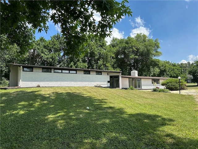 2550 Ivy Ln, Decatur, IL 62521 - mid-century inspired home featuring a front lawn, a chimney, and view of scattered trees