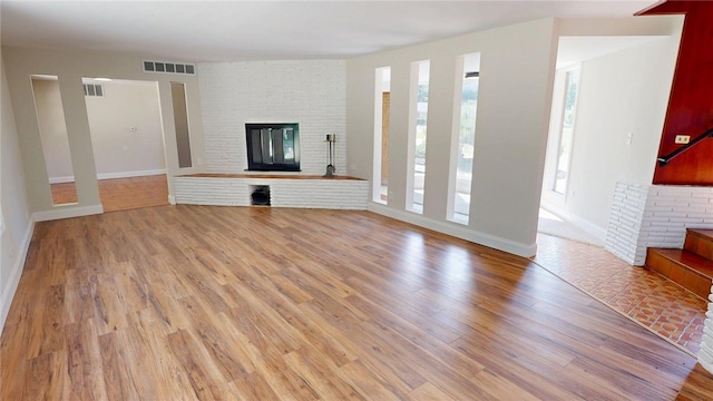 2550 Ivy Ln, Decatur, IL 62521 - unfurnished living room with light wood-type flooring and a brick fireplace