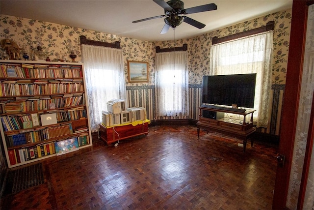 sitting room with parquet floors and ceiling fan