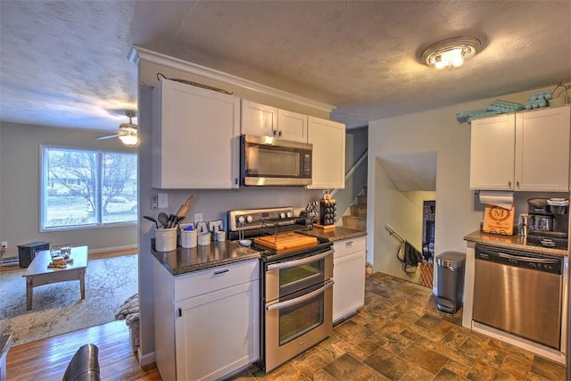 kitchen with white cabinetry, a textured ceiling, and appliances with stainless steel finishes