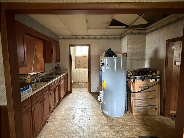 116 Warrington Ave, Danville, IL 61832 - kitchen with water heater, light countertops, and brown cabinetry