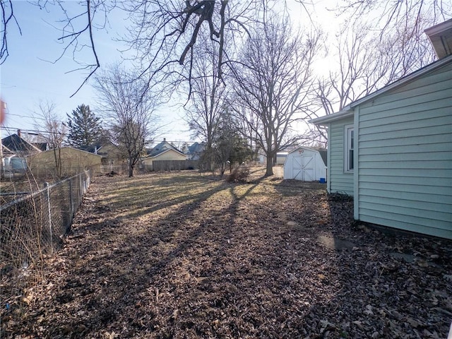 view of yard featuring an outbuilding, a fenced backyard, and a shed