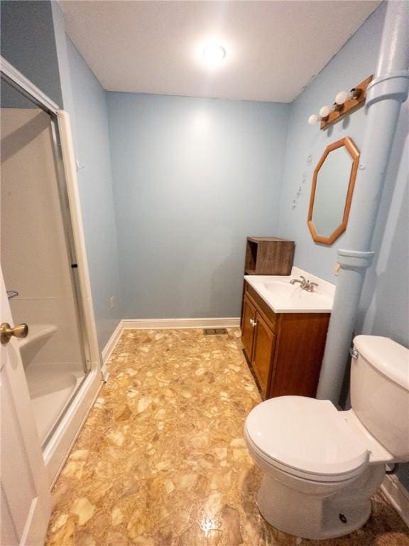 bathroom with baseboards, vanity, toilet, and a shower stall