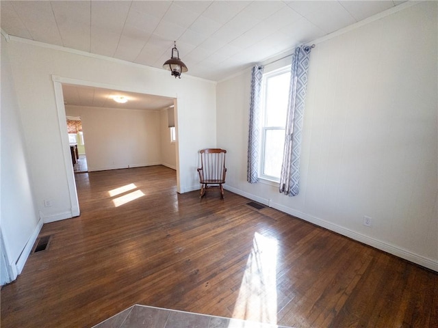 spare room with visible vents, baseboards, crown molding, and hardwood / wood-style flooring