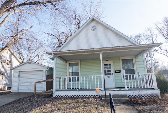 bungalow-style house with a detached garage, an outbuilding, covered porch, and concrete driveway