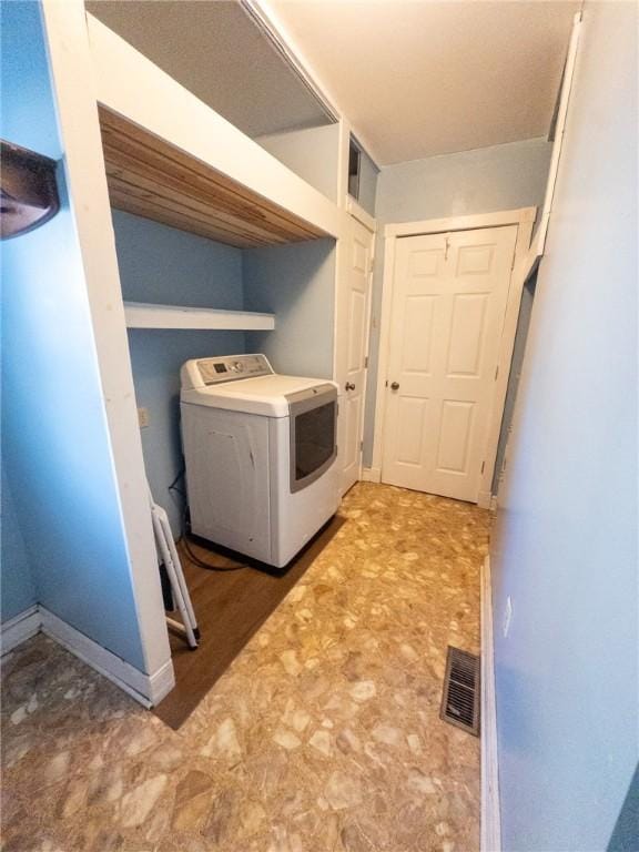 laundry room featuring visible vents, baseboards, laundry area, tile patterned floors, and washer / clothes dryer