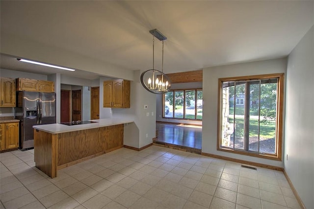 664 N Antler Dr, Mt Zion, IL 62549 - kitchen with refrigerator with ice dispenser, a chandelier, black electric cooktop, a peninsula, and light countertops