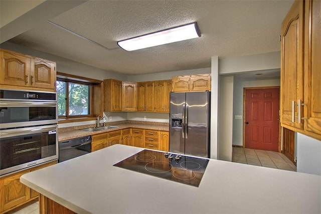664 N Antler Dr, Mt Zion, IL 62549 - kitchen featuring black appliances, a textured ceiling, brown cabinetry, light tile patterned floors, and light countertops