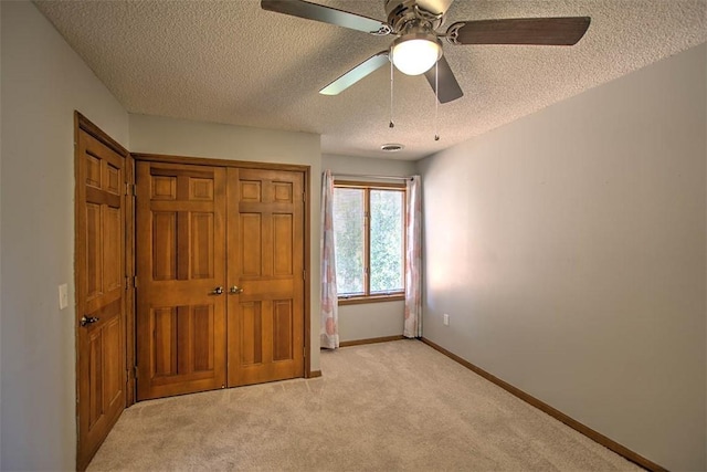 664 N Antler Dr, Mt Zion, IL 62549 - unfurnished bedroom with a textured ceiling, light colored carpet, a closet, and ceiling fan