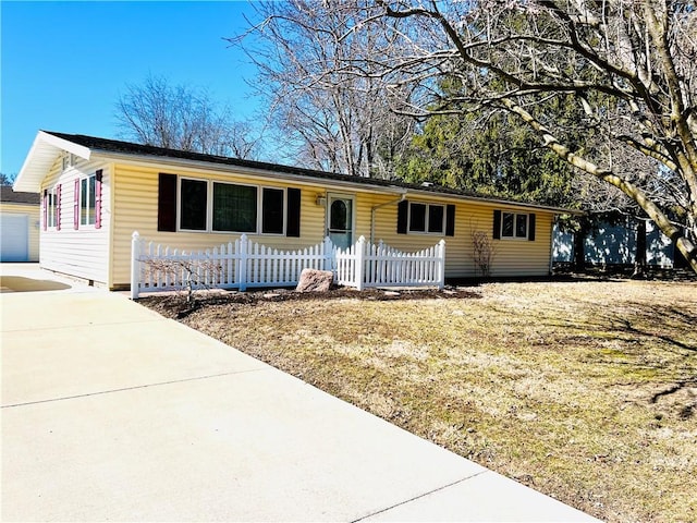 ranch-style home featuring a garage and a fenced front yard