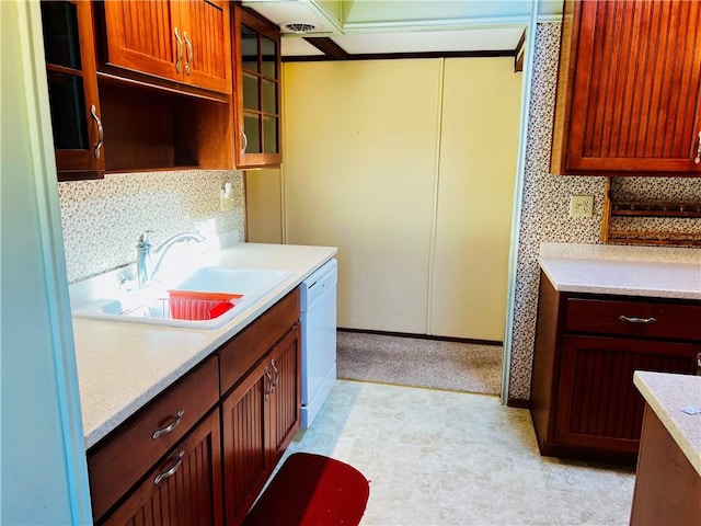 kitchen featuring a sink, decorative backsplash, light countertops, and dishwasher