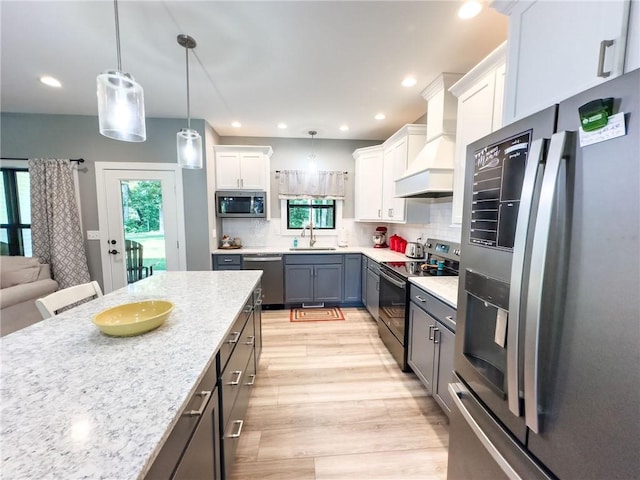 3 Wood Ridge Ln, Marshall, IL 62441 - kitchen with stainless steel appliances, custom range hood, light wood finished floors, decorative light fixtures, and backsplash