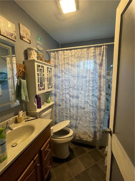 full bathroom with vanity, tile patterned floors, shower / bath combination with curtain, and toilet