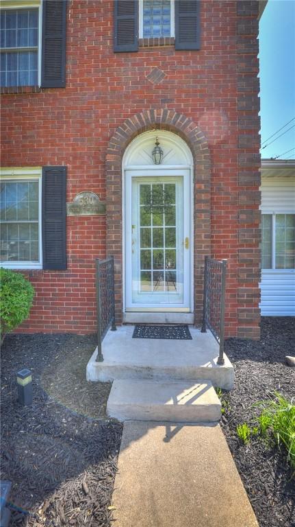 property entrance featuring brick siding