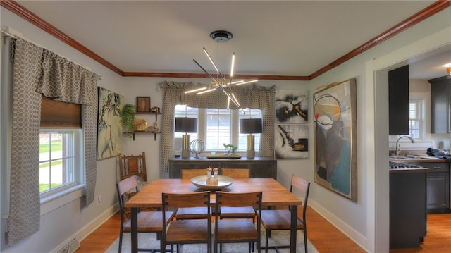 dining area with crown molding, baseboards, an inviting chandelier, and wood finished floors