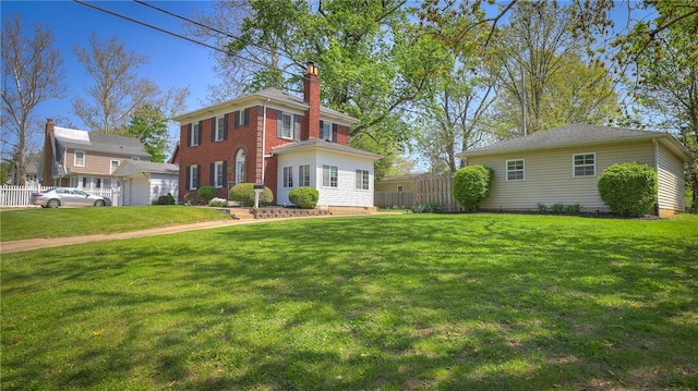 exterior space with fence, a front yard, and a chimney