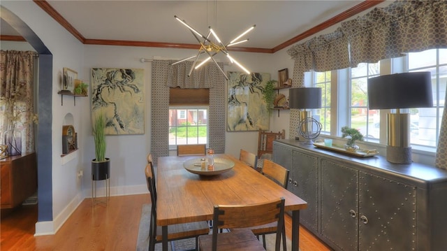 dining area with arched walkways, a wealth of natural light, and wood finished floors