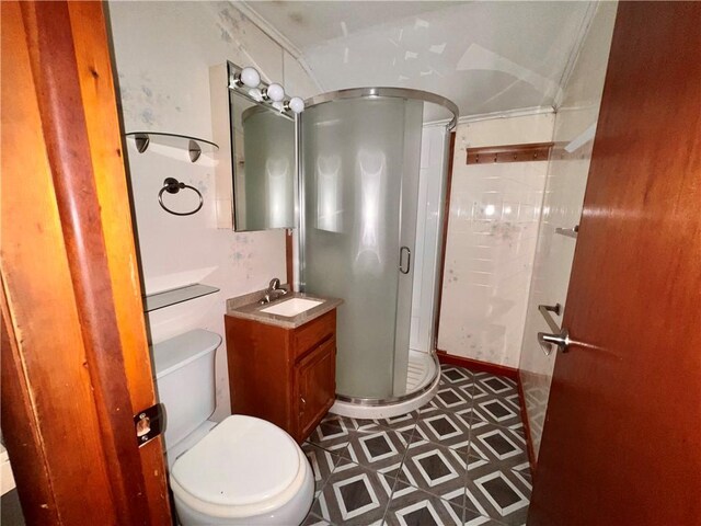 bathroom featuring tile patterned flooring, vanity, toilet, and a shower with shower door