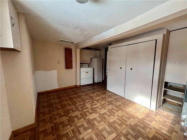 interior space with white fridge, washer / dryer, and parquet flooring