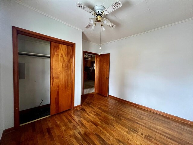 unfurnished bedroom with a closet, ceiling fan, dark hardwood / wood-style flooring, and ornamental molding