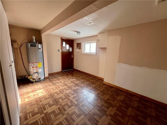 basement with parquet flooring and water heater