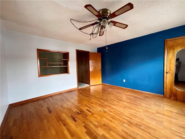 unfurnished room featuring a textured ceiling, light hardwood / wood-style flooring, and ceiling fan