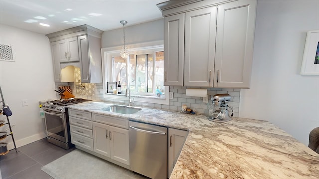 1805 N Gilbert St, Danville, IL 61832 - kitchen featuring decorative backsplash, pendant lighting, appliances with stainless steel finishes, a sink, and light stone counters