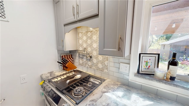 1805 N Gilbert St, Danville, IL 61832 - kitchen with light stone counters, decorative backsplash, gray cabinets, and stainless steel gas stove