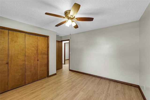 946 Foxcrest Dr, Charleston, IL 61920 - unfurnished bedroom featuring light wood-type flooring, a closet, a textured ceiling, and a ceiling fan