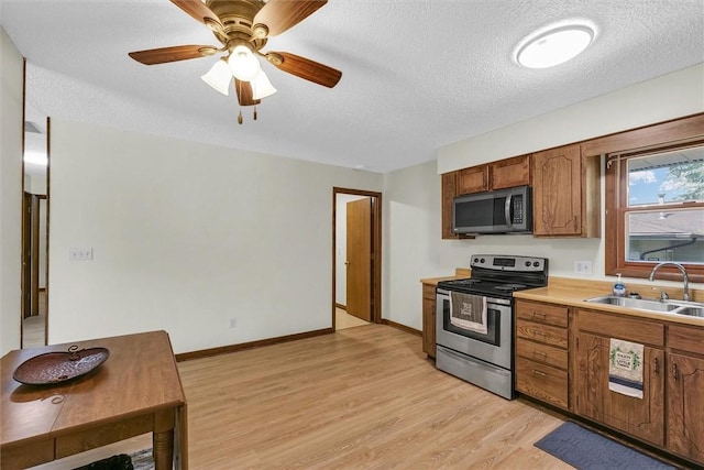 946 Foxcrest Dr, Charleston, IL 61920 - kitchen featuring appliances with stainless steel finishes, brown cabinets, light wood finished floors, a textured ceiling, and light countertops